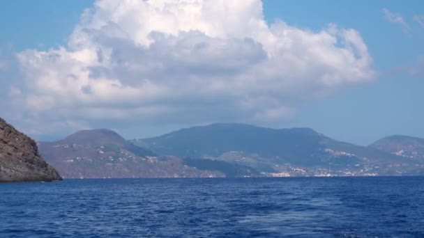 Vista sobre las islas Lipari en el mar Mediterráneo, Sicilia, Italia. Yate de vela blanco flotante. Montañas, edificios y cielo azul — Vídeos de Stock