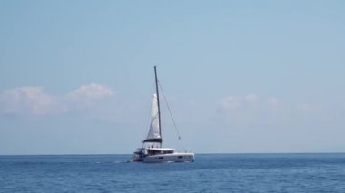 Akdeniz 'de turistlerle dolu beyaz yelkenli bir tekne. Lipari Adaları. Sicilya, İtalya. Ufuk, mavi gökyüzü