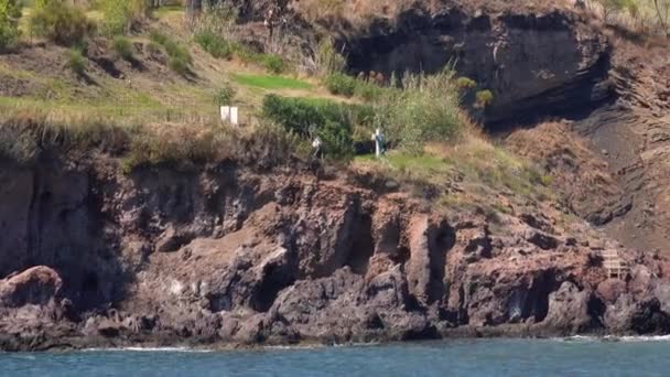 Littoral de l'île de Lipari. Montagne avec arbres verts, vignoble et petit cimetière. Mer Méditerranée. Journée ensoleillée d'été. Sicile, Italie — Video