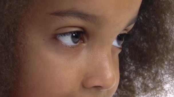 Afro amerikai göndör lány néz le a fehér háttér. Barna szemek hosszú fekete szempillákkal. Lassú mozgás. — Stock videók