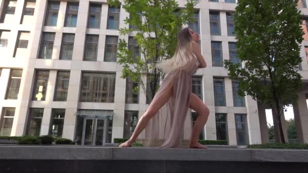 Menina bonita dançando na rua de um edifício moderno de um centro de negócios. Movimento lento . — Vídeo de Stock