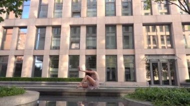 Modern bir şehrin caddesinde dans eden güzel genç kız suya yansıyor. Yavaş çekim