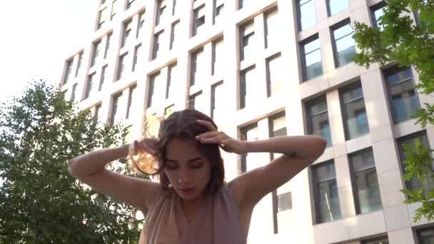 Hermosa joven bailando en la calle de un edificio moderno de un centro de negocios. De cerca. Movimiento lento . — Vídeos de Stock