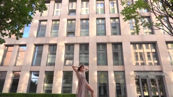 Schöne junge Mädchen tanzen auf der Straße einer modernen Stadt und spiegelt sich im Wasser wider. Zeitlupe — Stockvideo