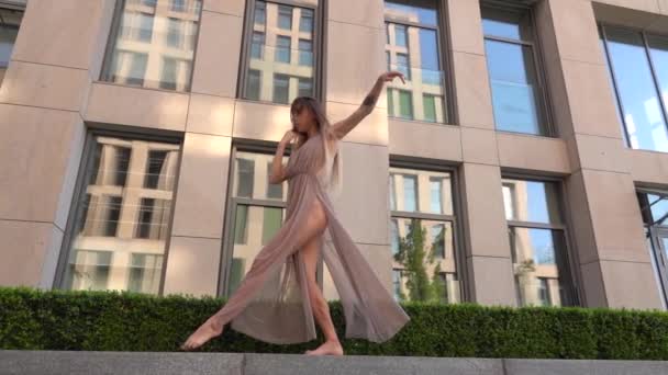 Beautiful young girl dancing performing contemporary on the street of a modern city. Slow motion. — Stock Video