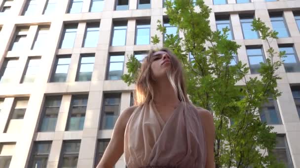 Beautiful young girl dancing on the street of a modern building of a business center. Close up. Slow motion. — Stock Video