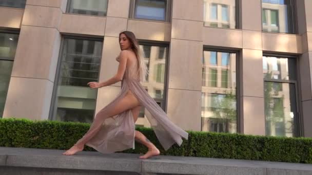 Beautiful young girl dancing on the street of a modern building of a business center. Slow motion. — Stock Video