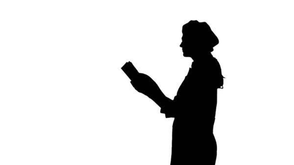 Silhouette noire de chef dame aux cheveux longs livre de cuisine de lecture . — Photo