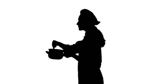 Porträt einer Köchin in Uniform, die Teller probiert. — Stockfoto