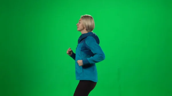 Молодая женщина бежит. Зеленый экран — стоковое фото