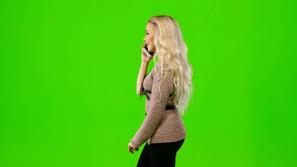 Blond meisje aan de telefoon. Groen scherm. Zijaanzicht — Stockfoto