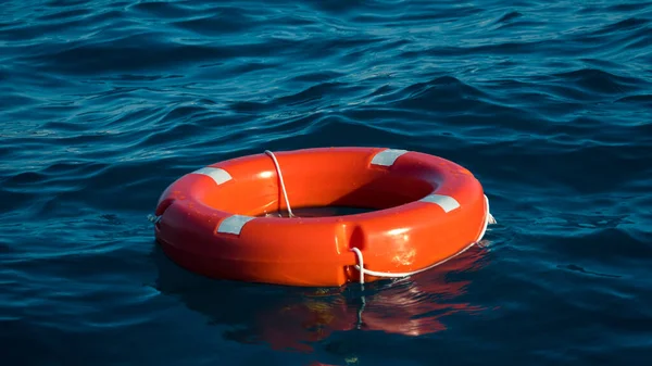 Σημαδούρα ζωής ή σημαδούρα διάσωσης που επιπλέουν στη θάλασσα για να σώσουν τους ανθρώπους από πνιγμό άνθρωπος. — Φωτογραφία Αρχείου