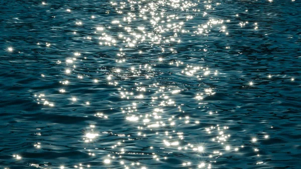 Rayos soleados jugando en las olas turquesas del mar. De cerca. Fondo de textura para el diseño . — Foto de Stock