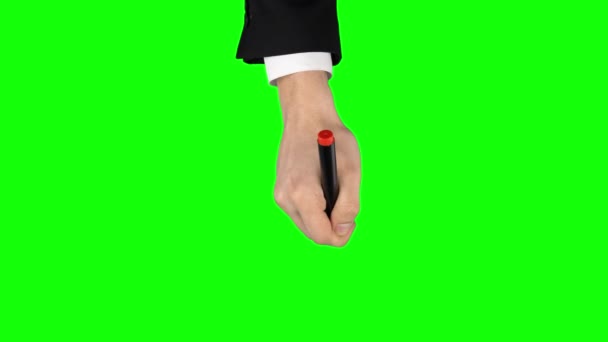 Mannelijke hand in een zwart jasje en wit shirt met rode stift schrijft op groen scherm achtergrond. Sluiten. — Stockvideo