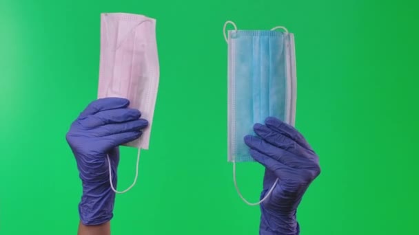 Doktor ukazuje dýchací masky, které drží v rukou vybavení chráněné modrými lékařskými rukavicemi. Zelená obrazovka. Zavřít. — Stock video