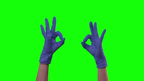 Artsen vrouwelijke handen in blauwe handschoen is het maken van gebaren Ok. Groen scherm. Sluiten. — Stockvideo