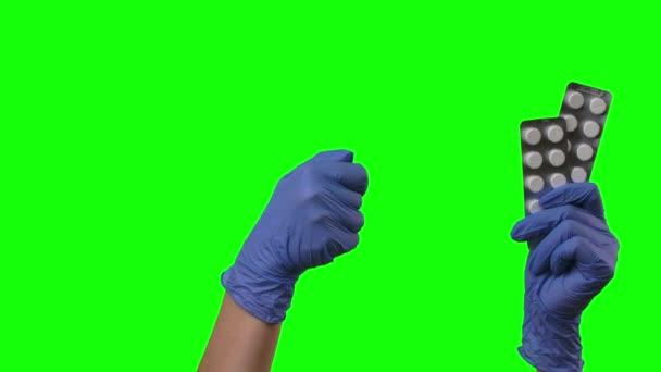 Le docteur montre des pilules et fait des gestes comme. Mains féminines en gants bleus protecteurs en gros plan à l'écran vert . — Video