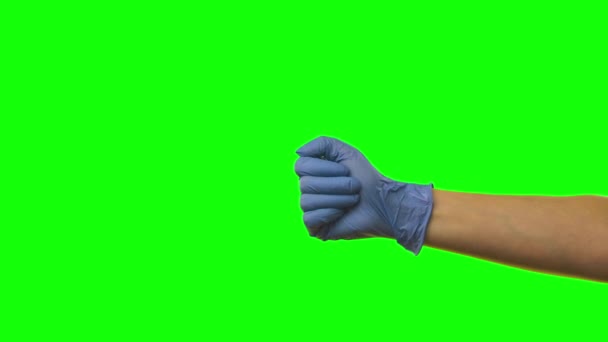 Рука женщины в синей перчатке показывает, что палец вниз жесты неприязни. Зеленый экран. Закрыть — стоковое видео