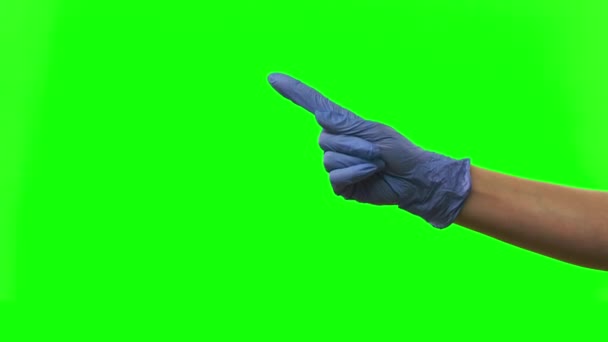 Doctors female hand in blue glove is making symbolic gestures pointing something. Green screen. Close up — Stock Video