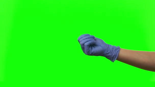 Doctors female hand in blue glove is opens palm showing something with copy space at green screen. Close up — Stock Video