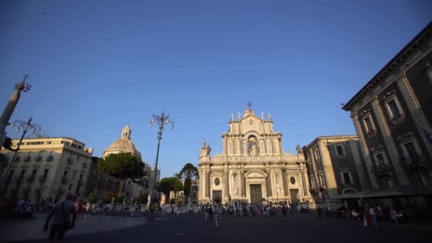 CATANIA, SICILIA, ITALIA - SEPTIEMBRE 2019: Catedral Católica Romana con esculturas, columnas, fachada decorada. Árboles verdes, turistas caminando — Vídeo de stock