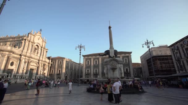 KATANIA, SICILY, WŁOCHY - WRZESIEŃ 2019: Fontanna, rzymska rzeźba słonia stojąca na środku placu. Spacerujący turyści, błękitne niebo — Wideo stockowe