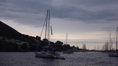 Akdeniz 'e demir atmış yelkenliler. Dağ, yeşil ağaçlar ve binalar. Lipari Adaları, Sicilya, İtalya