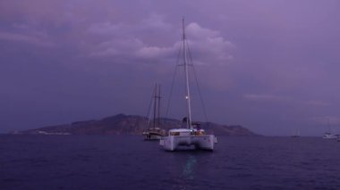 Akdeniz 'de demirlemiş ışık, yelkenli ve yatları olan bir katamaran. Lipari Adası. Bulutlu gökyüzü. Sabah erkenden. Sicilya, İtalya