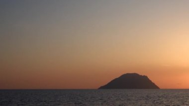 Akdeniz 'deki Lipari Adası ufka karşı, açık renkli gökyüzü. Yaz gündoğumu. Sicilya, İtalya