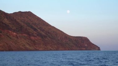 Akdeniz 'deki Lipari Adası ufuk çizgisine karşı, uydulu renkli gökyüzü. Dalgalanan su yüzeyi. Yaz batımı. Sicilya, İtalya