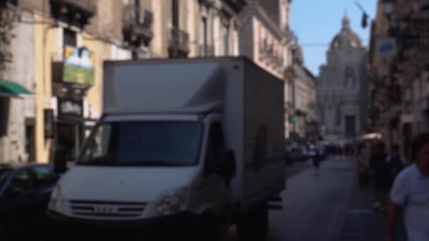 CATANIA, SICILY, ITALY-SEPT, 2019: Blurred motion of street, view on dome of Roman Catholic cathedral.商店，咖啡馆。停车，移动的汽车。游客 — 图库视频影像