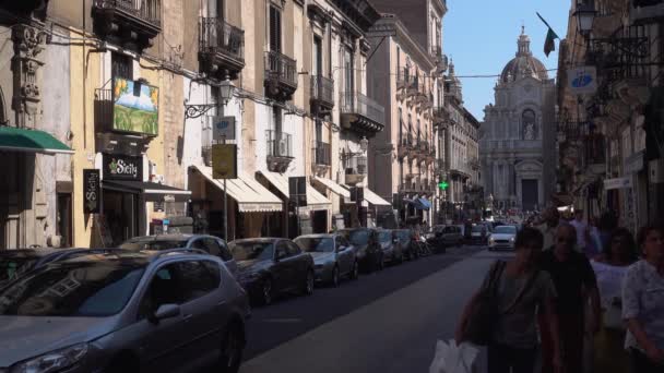 CATANIA, SICILY, ITALY - SEPT, 2019: Οδός με θέα στον τρούλο του Ρωμαιοκαθολικού καθεδρικού ναού. Παλιά κτίρια. Καταστήματα, καφετέριες. Πάρκαρε, μετακινούσε αυτοκίνητα. Τουρίστες — Αρχείο Βίντεο