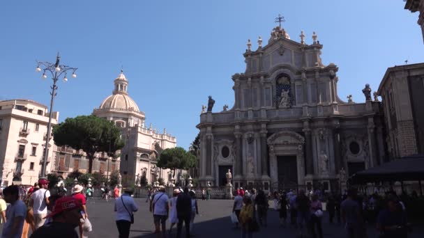 CATANIA, SICILY, ITALY - SEPT, 2019: heykelleri ve sütunları olan Roma Katolik katedrali. Etrafı tarihi binalarla çevrili. Yürüyen turistler. Mavi gökyüzü — Stok video