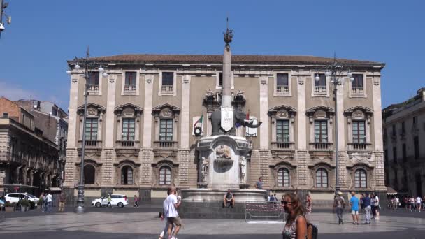 CATANIA, SICILY, ITALY - SEPT, 2019: Fountain, statue of elephant standing in center of square, against Elephants Palace. Walking tourists, blue sky — Stock Video