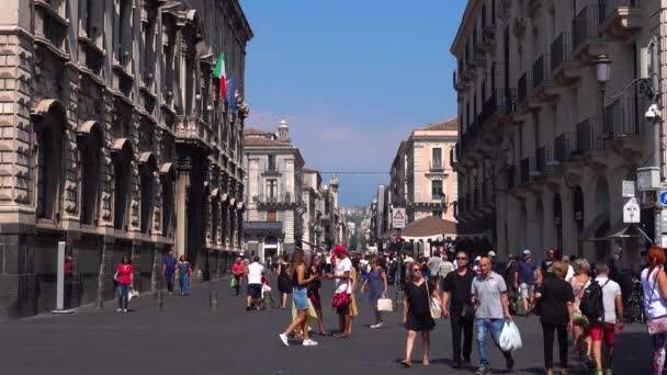 CATANIA, SICILY, ITALY-SEPT, 2019:游客走过被古代历史建筑环绕的广场.沿着大街行驶的公共汽车。阳光灿烂 — 图库视频影像