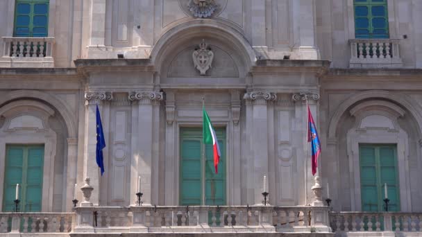 KATANIA, SICILY, WŁOCHY - WRZESIEŃ 2019: Balkon najstarszego Uniwersytetu na świecie. Starożytny budynek z flagami, rzeźbami i kolumnami na fasadzie. Zamknij się. — Wideo stockowe