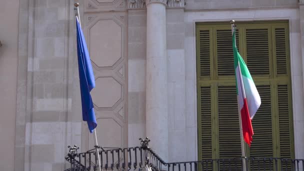 Flagi Włoch i Europy Unia macha na balkonie Palazzo San Giuliano w Katanii, Sycylia, Włochy. Zamknij się. — Wideo stockowe