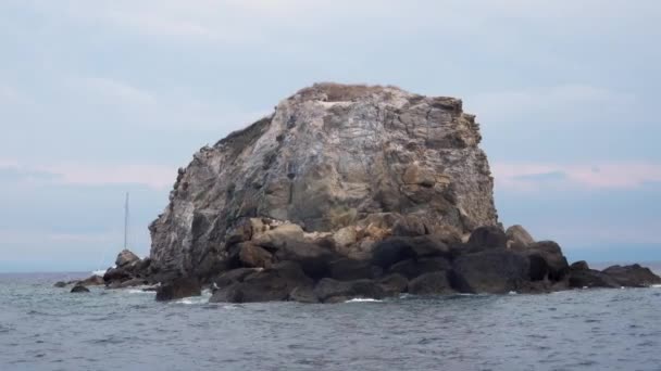 Lonely high rock in Mediterranean sea against horizon, cloudy sky. Lipari Islands, Sicily, Italy — Stock Video