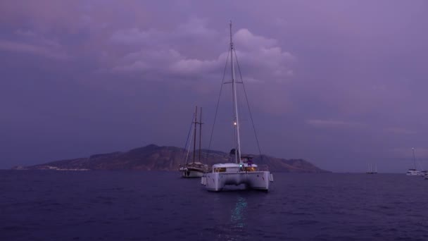 Katamaran med ljus, segelbåt och båtar förankrade i Medelhavet. Lipari-ön. Molnig himmel. Tidig morgon. Sicilien, Italien — Stockvideo