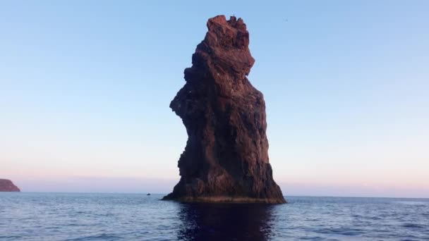 Felsen im Mittelmeer gegen Horizont und Insel Lipari. Bunter Himmel, Sonnenaufgang. Plätschernde Wasseroberfläche. Sizilien, Italien — Stockvideo