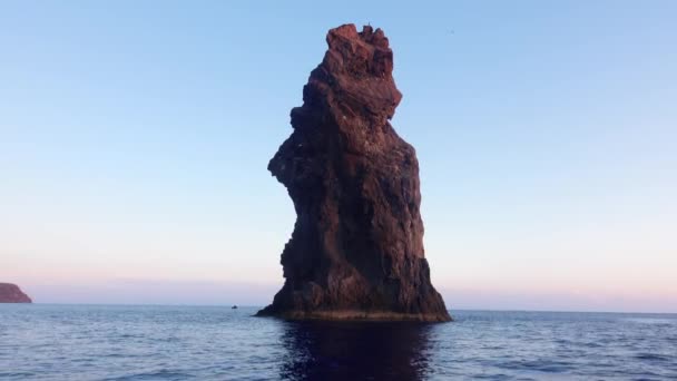 Скала в Средиземном море против горизонта и острова Липари. Красочное небо, восход солнца. Поверхность речной воды. Сицилия, Италия — стоковое видео