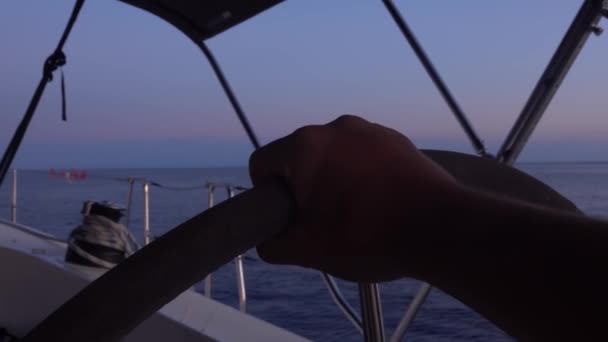 Mãos de homem voltando volante de veleiro em movimento. Mar Mediterrâneo, horizonte. Céus coloridos. Fechar — Vídeo de Stock