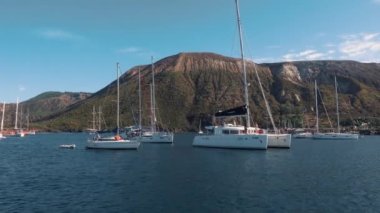 Akdeniz kıyısı yakınlarında beyaz katamaranlar ve yelkenli yatları. Lipari Adaları, Sicilya, İtalya
