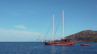 Tahta yelkenli, arkasında yüzen lastik tekne. Akdeniz 'de. Lipari Adaları, Sicilya, İtalya