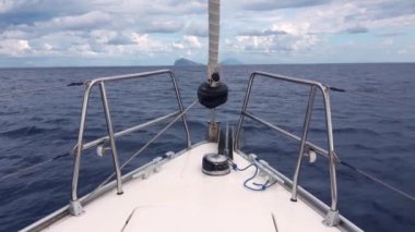 Dağlara doğru yüzen beyaz yelkenlinin burnundan bak. Lipari Adaları, Sicilya, İtalya