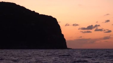 Büyük bir dağ, Akdeniz ve gri bulutlu renkli bir gökyüzü. Lipari Adaları, Sicilya, İtalya