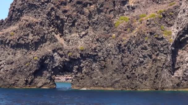 지중해의 리파리 섬에 있는 바위 틈에서 수영하는 사람들이 있습니다. 여름의 화창 한 날, 푸른 하늘. 이탈리아 의시 칠리아 — 비디오