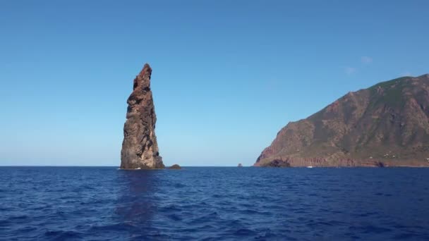 Rocas en el mar Mediterráneo contra el horizonte y la isla de Lipari. Cielo azul, día soleado de verano. Sicilia, Italia — Vídeo de stock