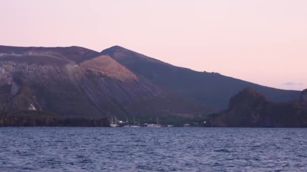 Segelboote und Yachten ankern im Mittelmeer am Fuße der Insel Lipari. Sonnenuntergang oder Sonnenaufgang. Sizilien, Italien — Stockvideo