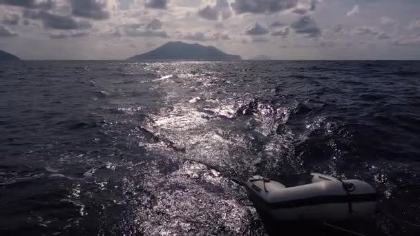 Bateau gonflable en caoutchouc attaché au yacht, flottant derrière. Îles Lipari, Sicile, Italie. Mouvement lent — Video